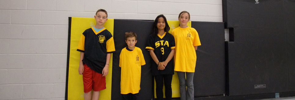 St. Thomas Aquinas Catholic School athletes wearing yellow and black sports uniforms.